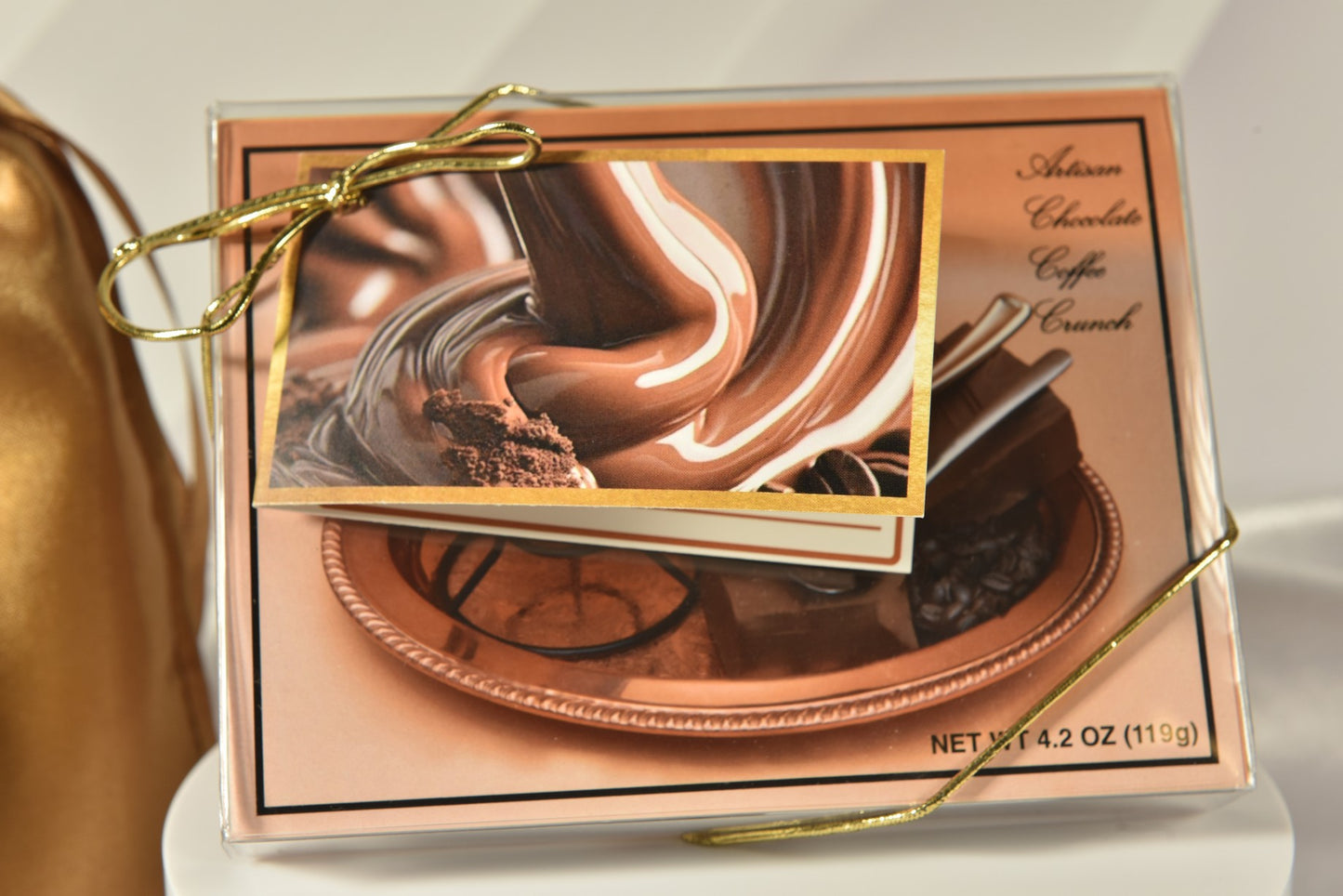 A box of European-style milk chocolates with roasted coffee, presented with a gold cord and a personal message card, possibly including a satin gold drawstring pouch.